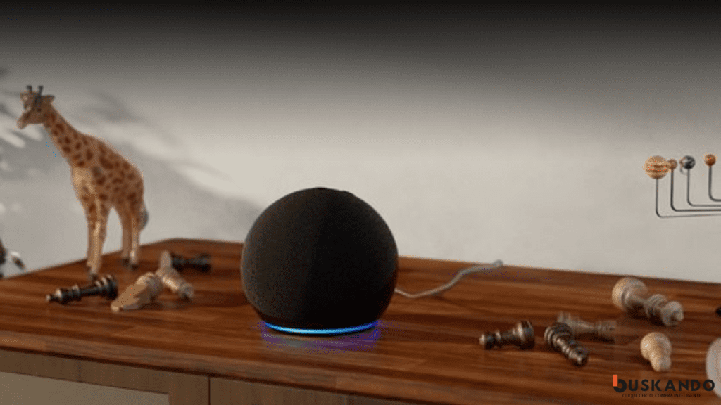 Echo Dot preto em primeiro plano com peças de xadrez e uma girafa de brinquedo ao fundo em uma superfície de madeira.