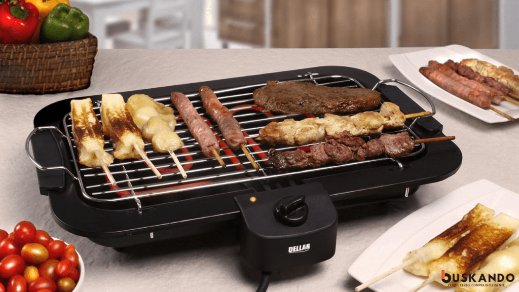 Churrasqueira elétrica com variedade de carnes e queijo grelhados, cercada por vegetais frescos e uma travessa com mais espetinhos ao lado.